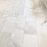 a shining white marble floor with a white tile floor